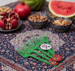 تزیین میز و سرو میوه شب یلدا با چنگال سبز و ظروف تم انار و هندوانه